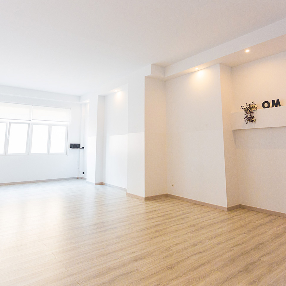 Sala blanca con ventanal y tarima de madera color marrón suave